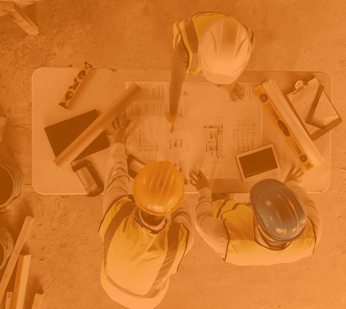 Construction planners reviewing drawings at a site table