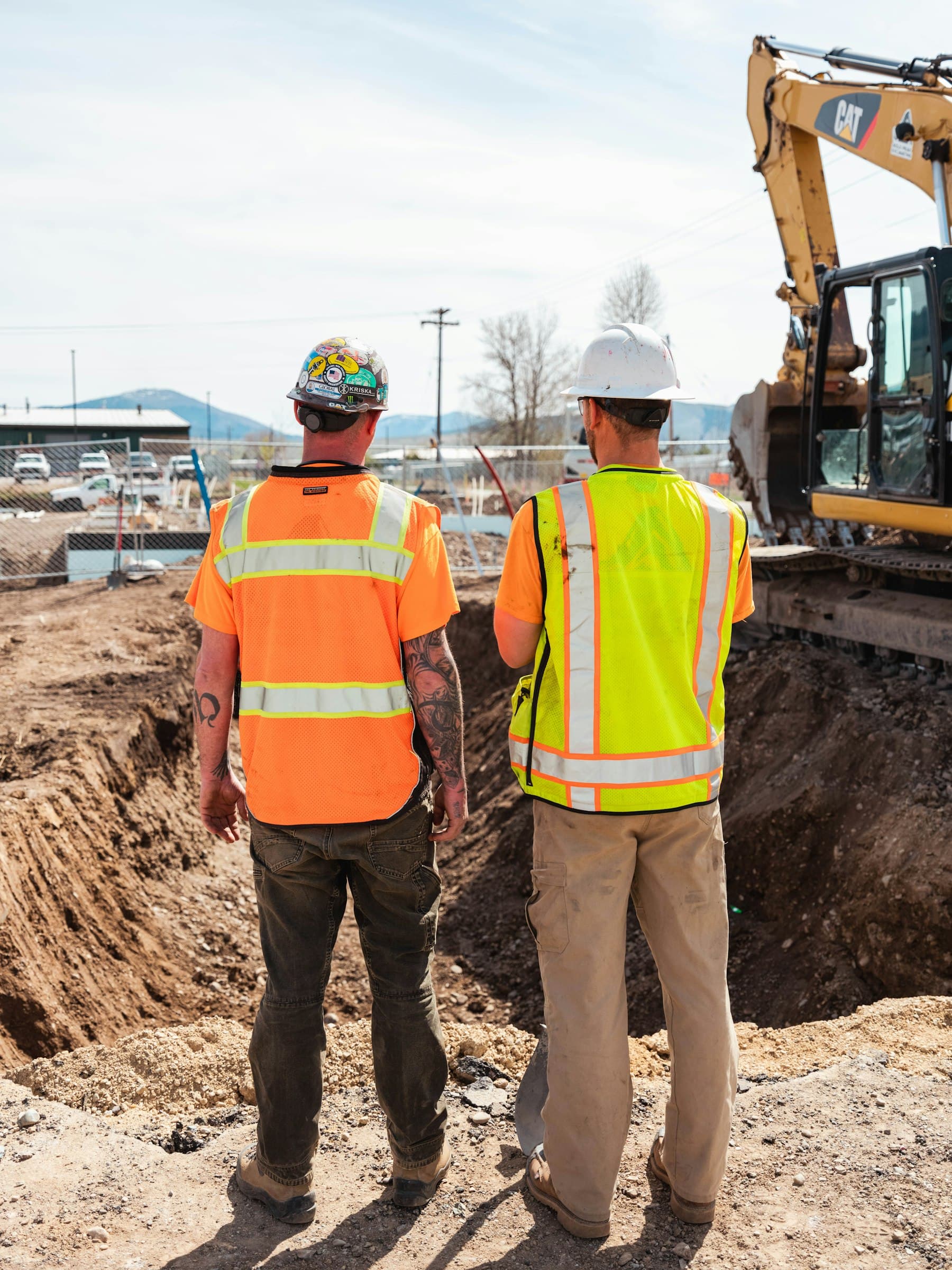 Site leaders reviewing project operations near heavy equipment